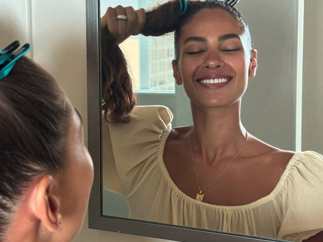Femme se coiffant au miroir avec une pince magnétique Klipix